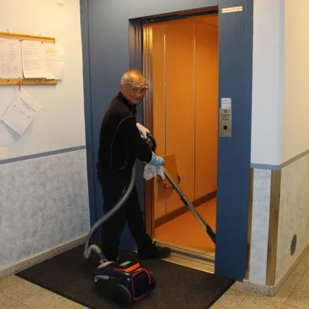 Medarbetare dammsuger golvet i en hiss
